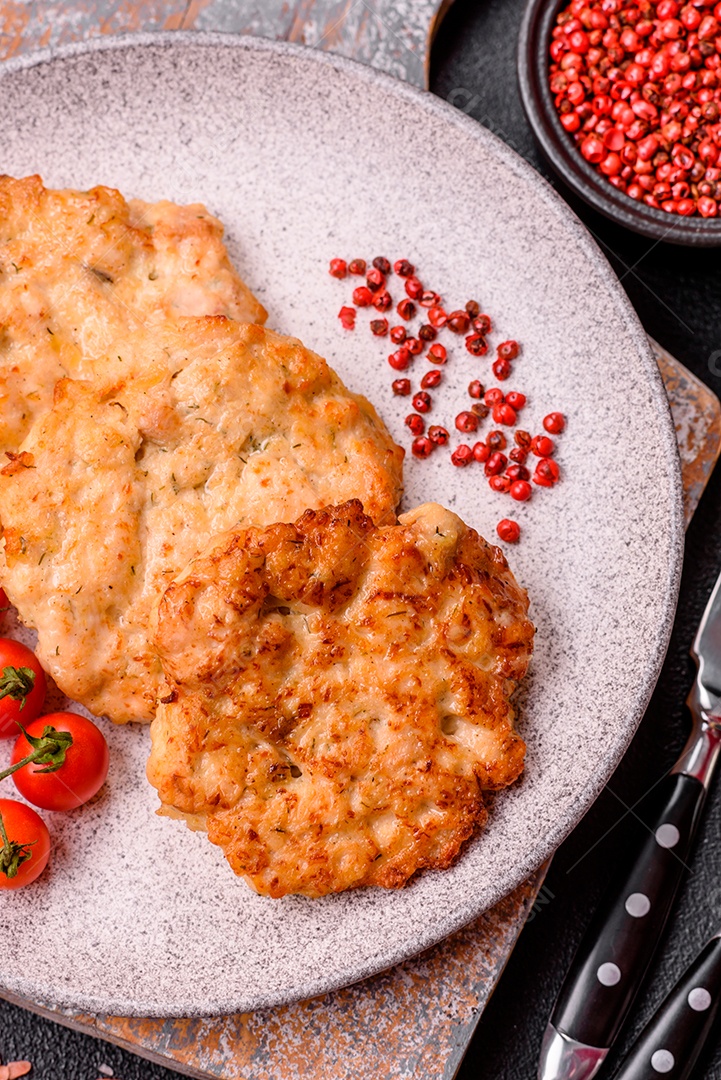 Carne a milanesa sobre prato em uma mesa de concreto