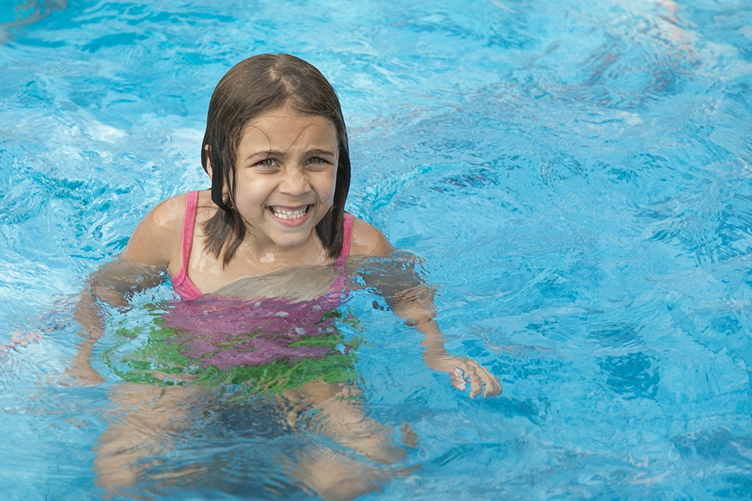 Garotinha fofa nadando em uma piscina