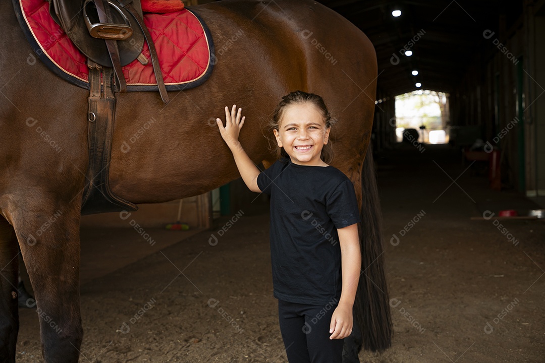 Linda garotinha ao lado de um cavalo