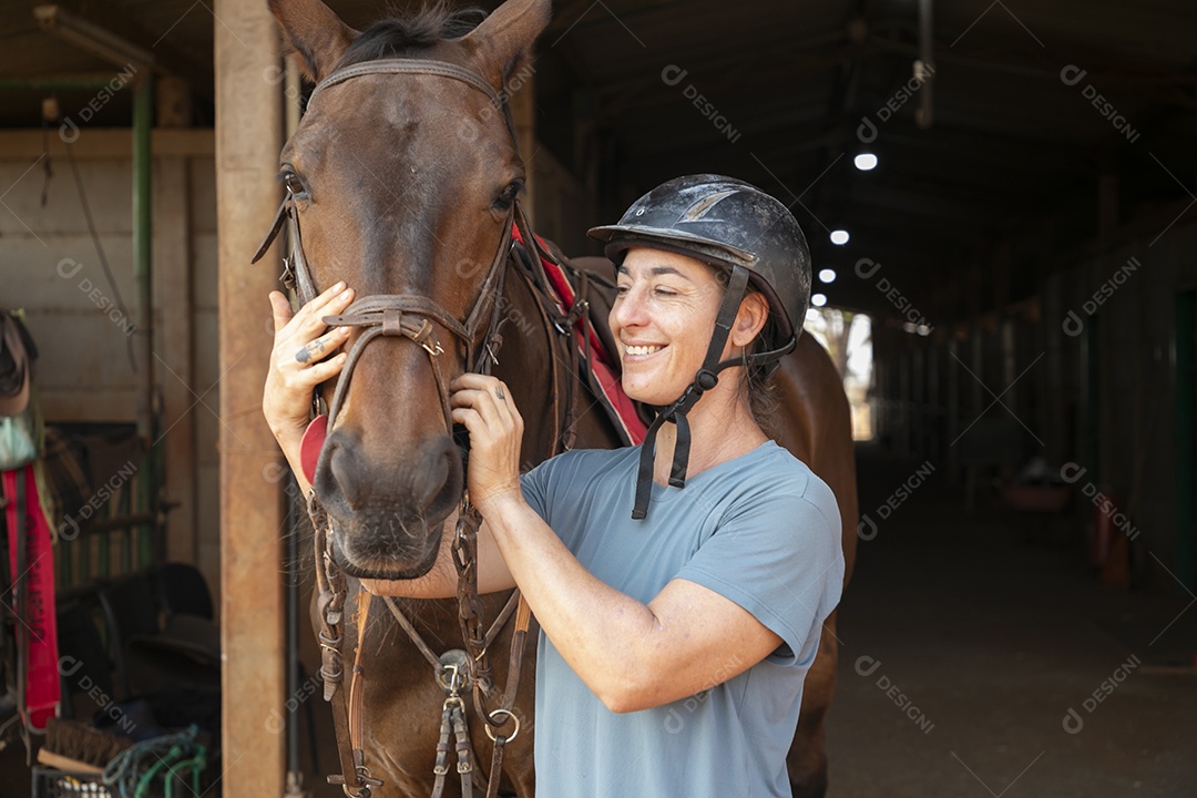 Mulher ajeitando rédeas de seu cavalo