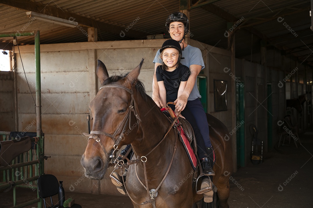 Treinadora se divertindo ao ensinar hipismo para garotinha