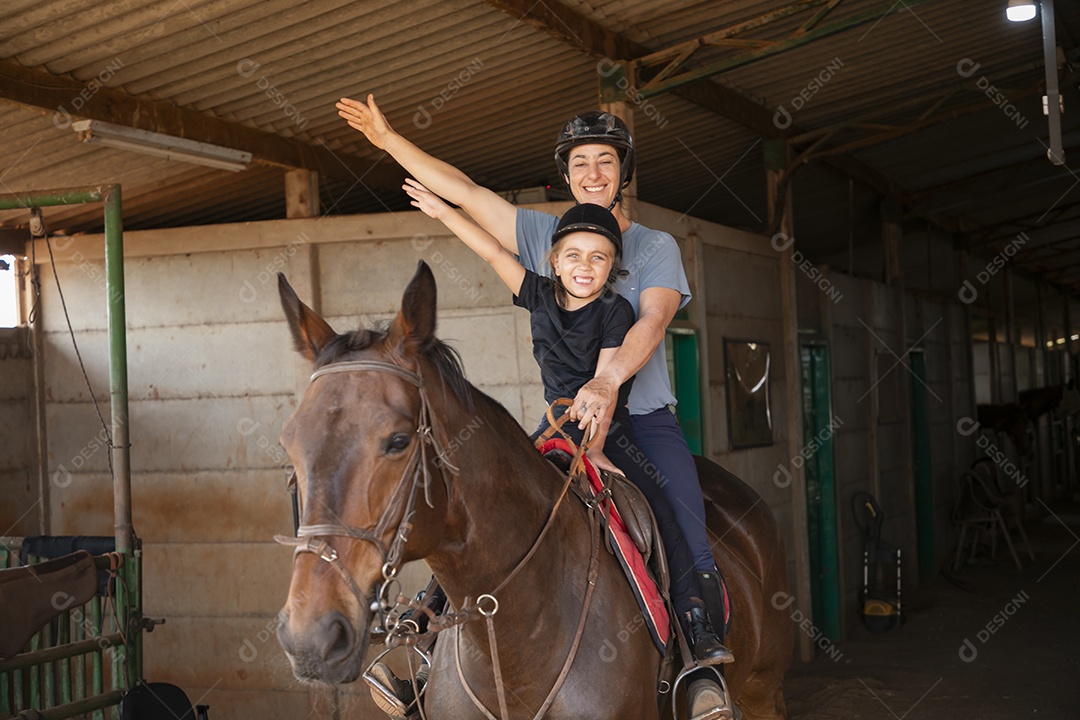 Treinadora se divertindo ao ensinar hipismo para garotinha