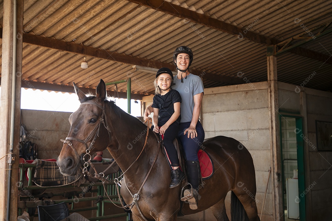 Treinadora e sua aluna em treino de hipismo