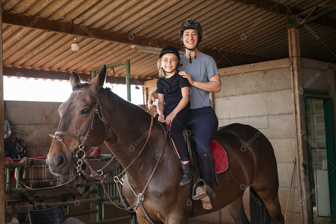 Treinadora e sua aluna em treino de hipismo