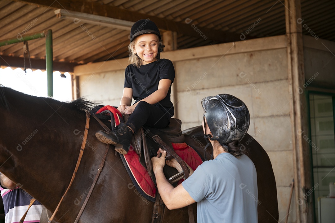 Menina linda e feliz com suas aulas de hipismo