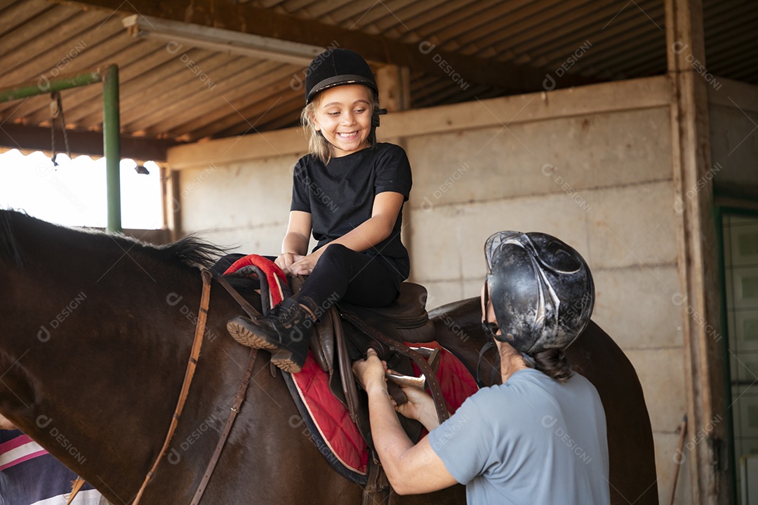 Garotinha muito feliz com sua aula de hipismo