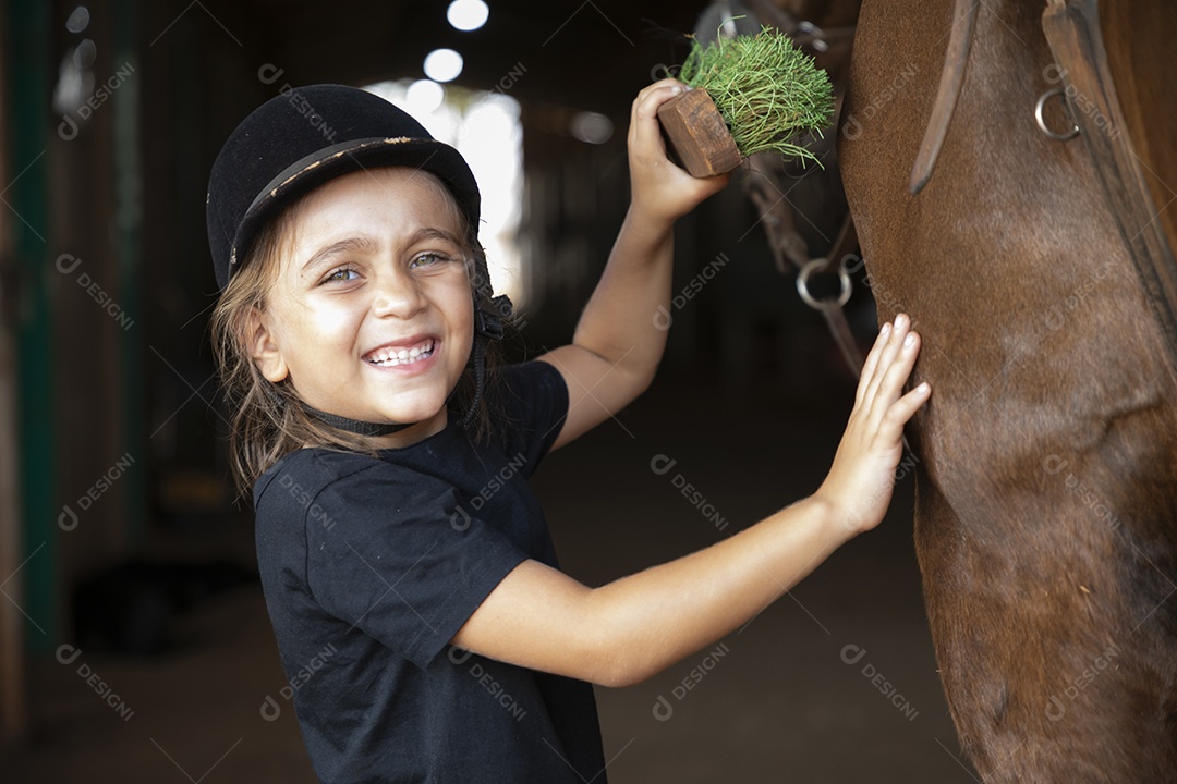 Linda menina escovando seu cavalo de treino
