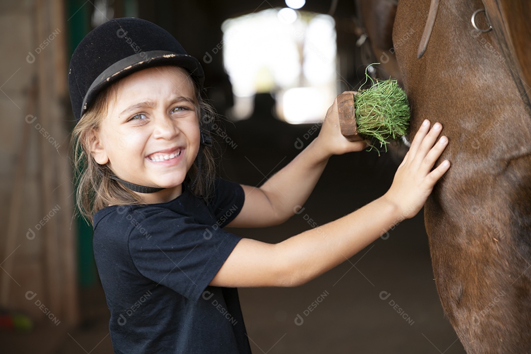 Linda garotinha escovando seu cavalo