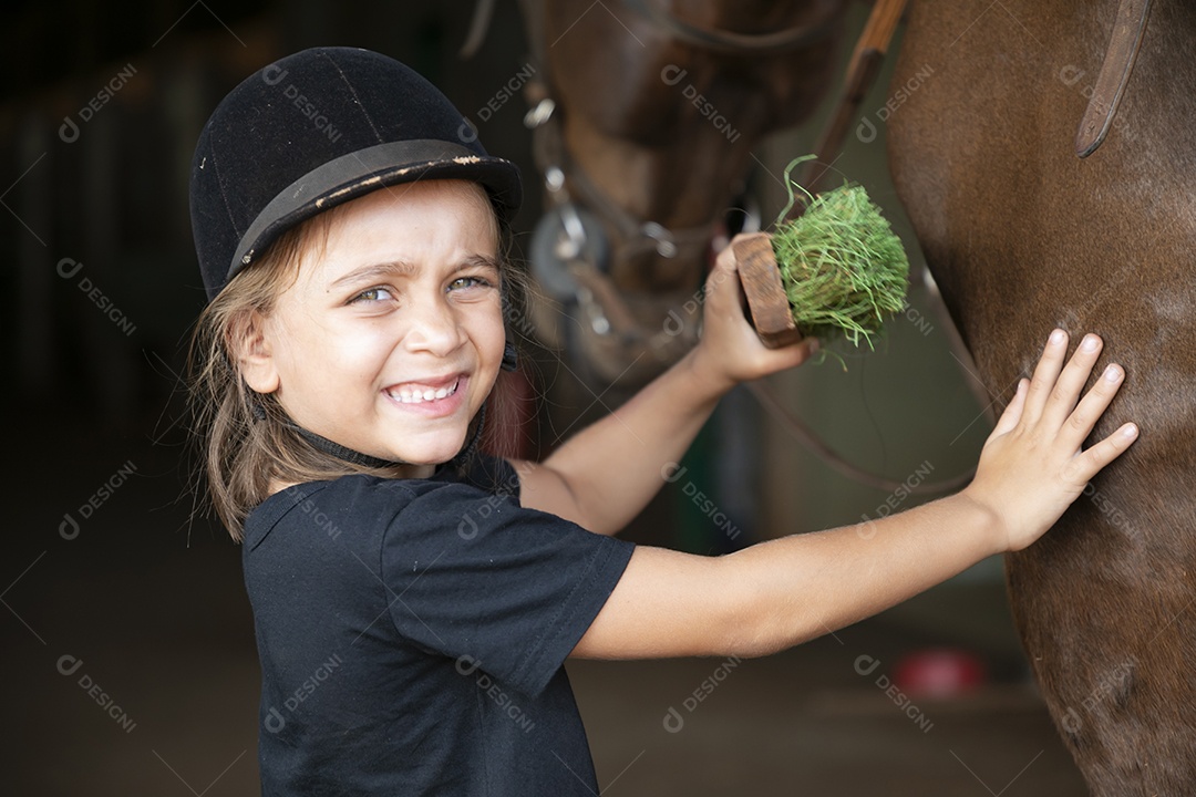 Cavaleira mirim escovando seu cavalo de treino