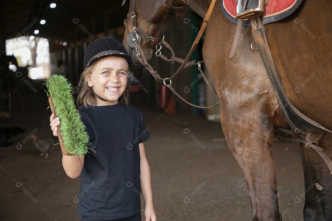 Menina linda ao lado de um cavalo para ser escovado