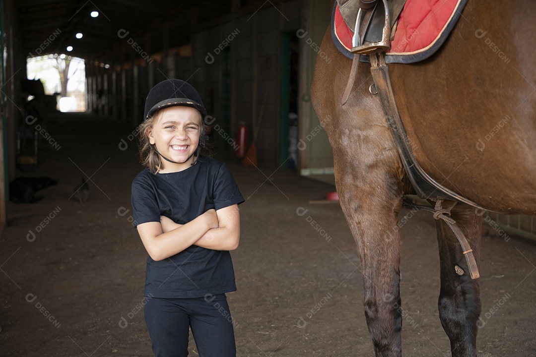 Uma linda garotinha ao lado de uma cavalo para aula de hipismo