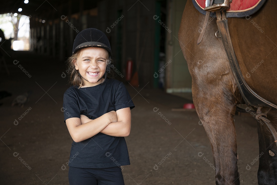 Garotinha feliz trajada para aulas de hipismo