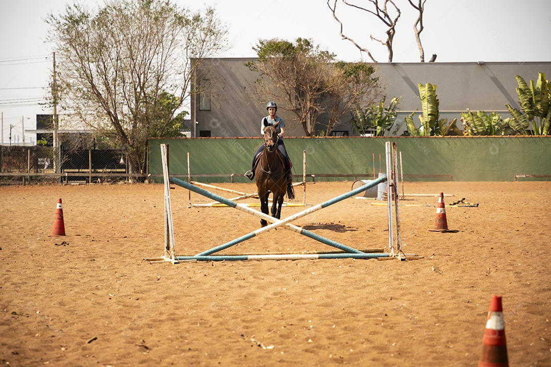 Mulher cavalgando em obstáculo