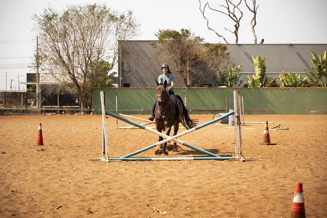 Mulher cavalgando em obstáculo