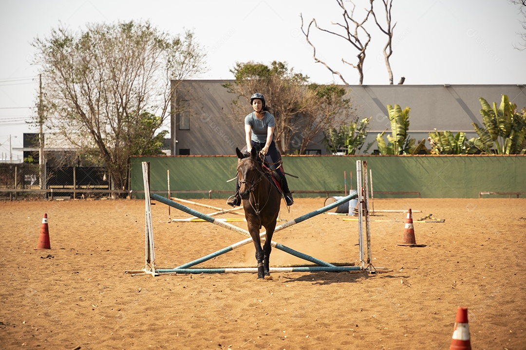 Mulher cavalgando em obstáculo