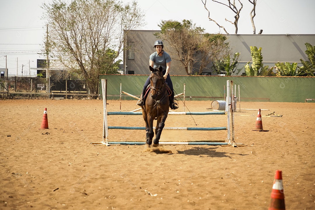 Mulher saltando de cavalo em aula de hipismo