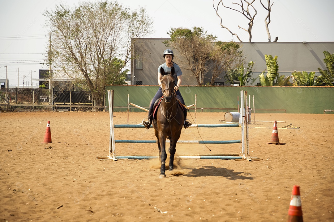 Aula de hipismo mulher passando obstáculos