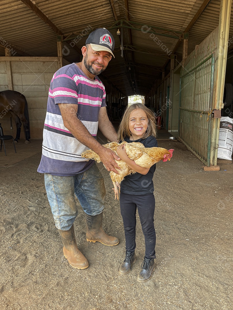Homem dando galinha para menina