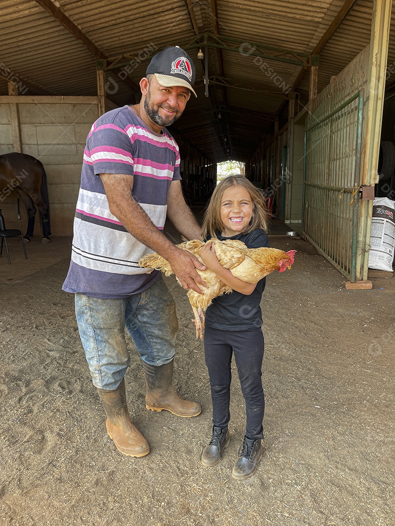 Um homem e uma garotinha com frango na mãos