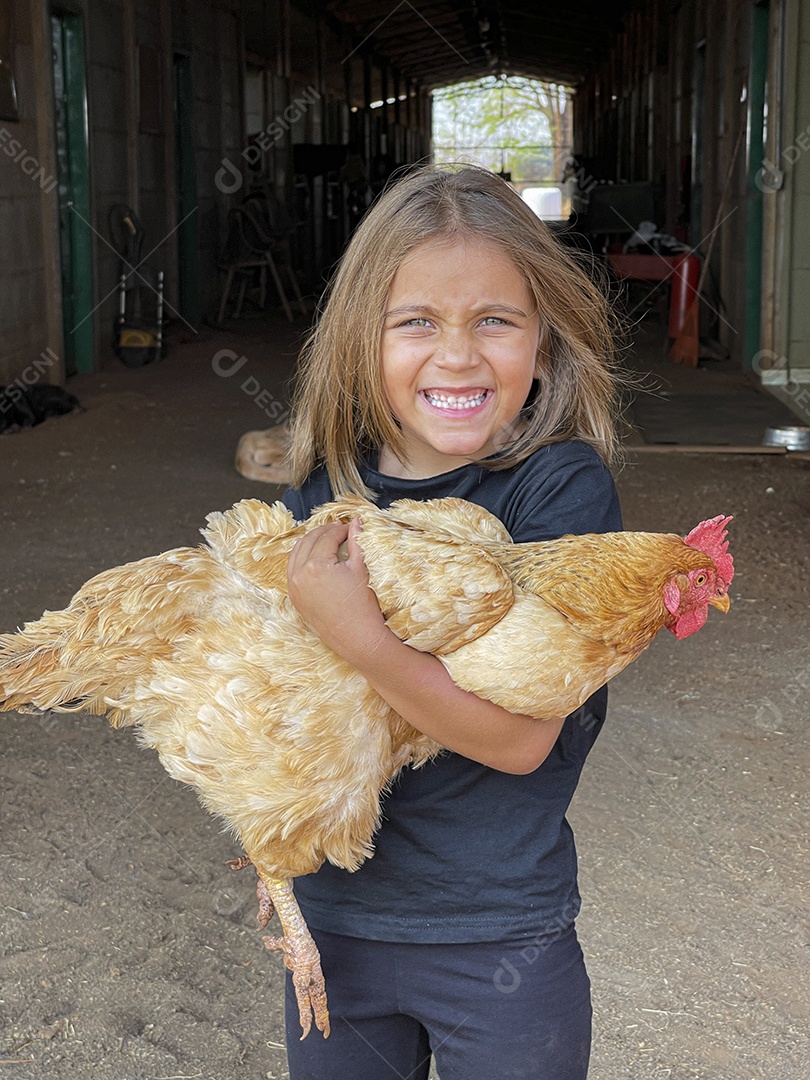 Linda menina com frango nas mãos