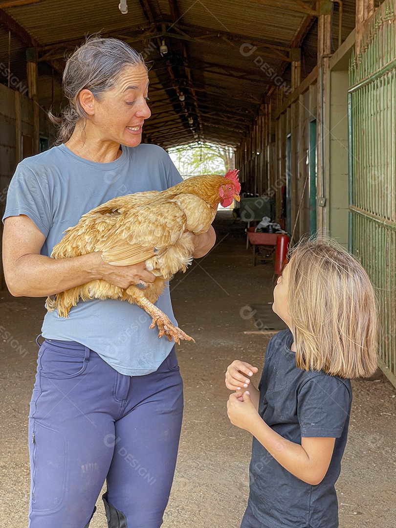 Mulher com frango e uma criança linda