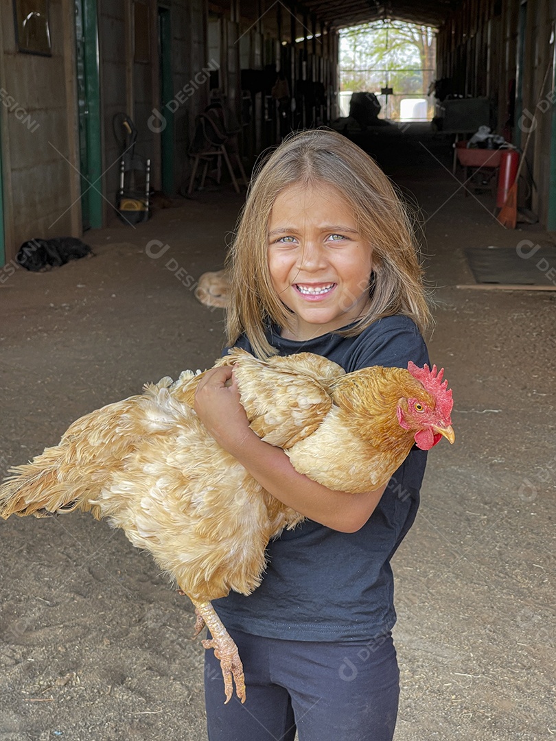 Linda garotinha segurando galinha