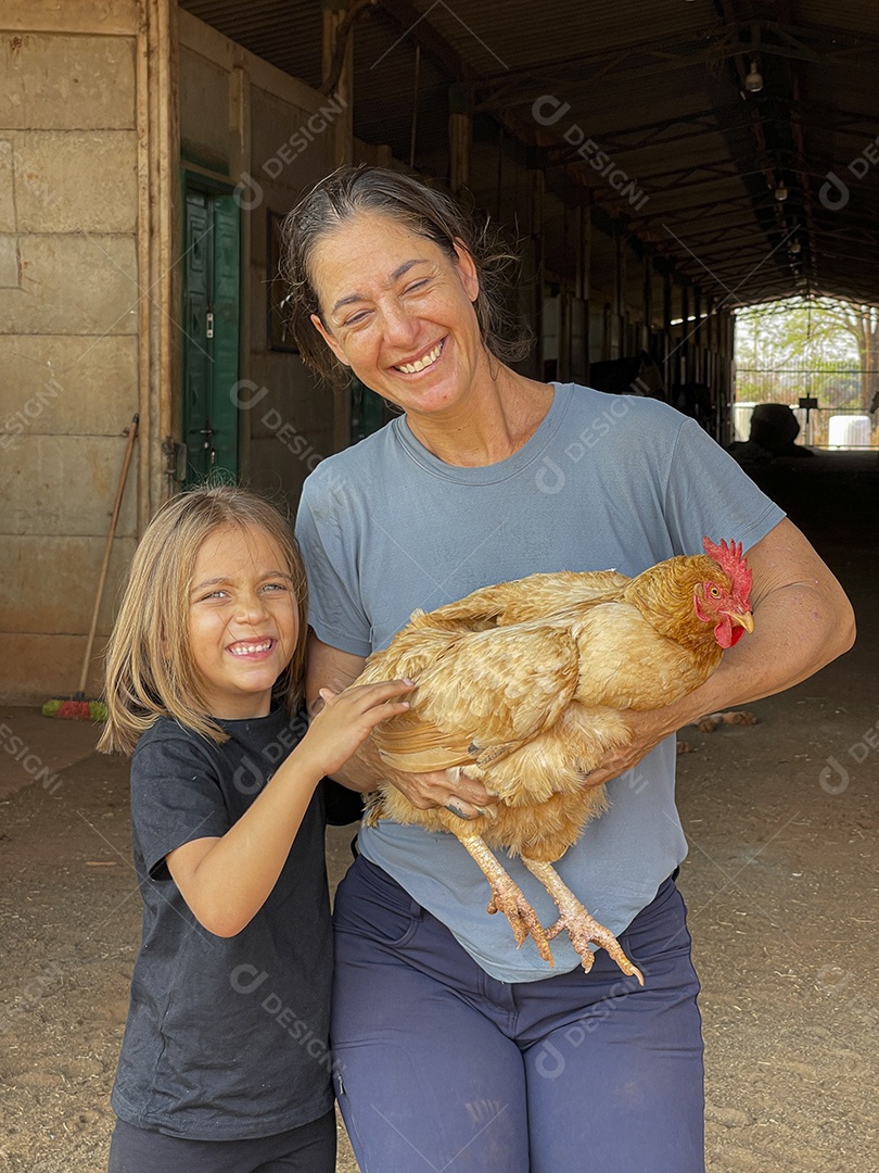 Mulher e uma criança com galinha nas mãos