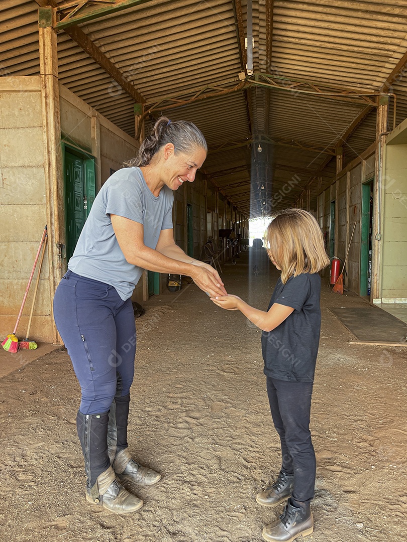Mulher colocando alguma coisa na mão de uma menina