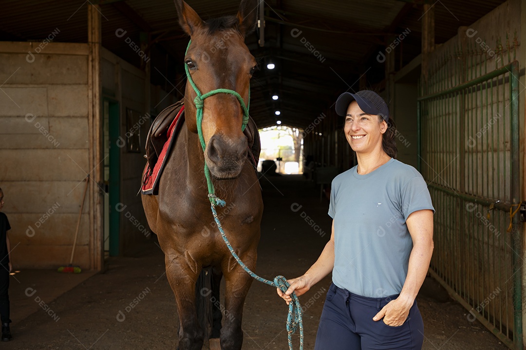 Cavalo e uma mulher segurando a rédeas