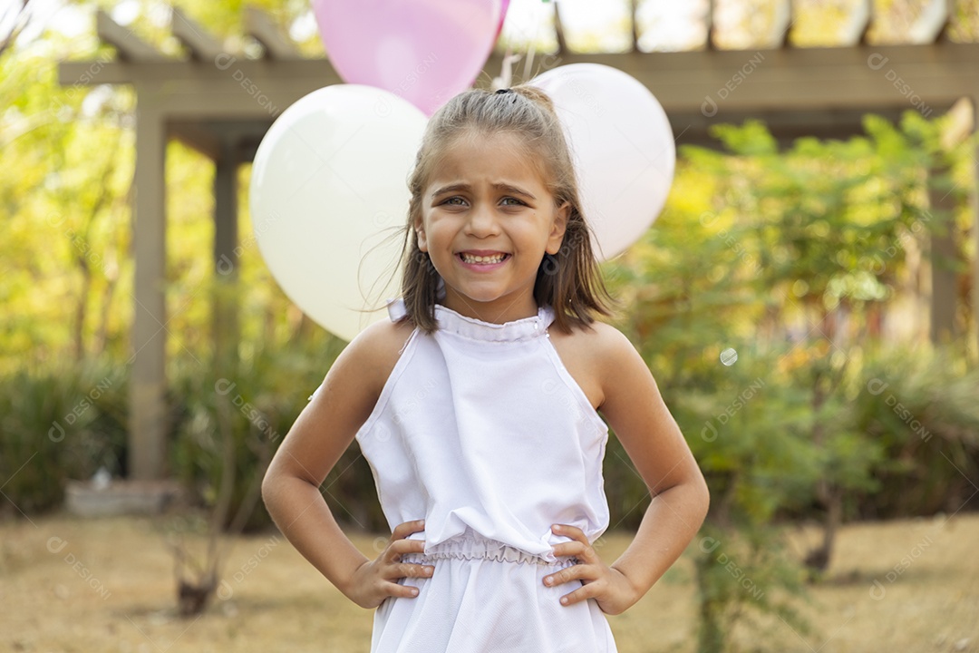 Linda garotinha com mãos na cintura sorrindo
