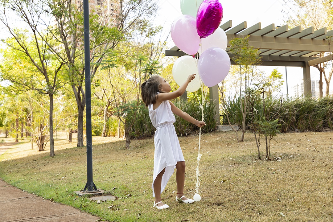 Linda menina com balões posando para fotos de aniversário