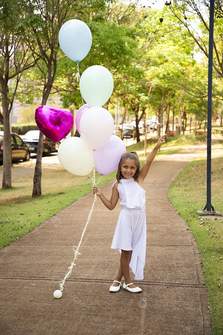 Linda menininha posando para fotos com balões