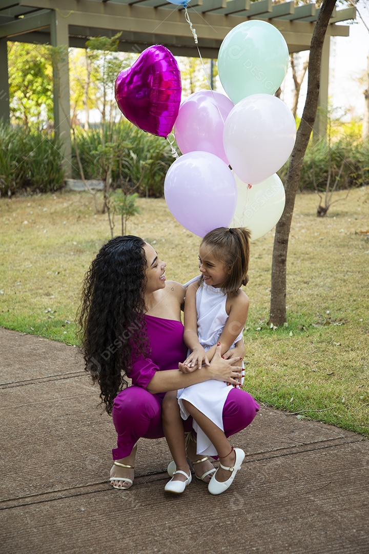 Mãe com sua filha no colo para fotos de aniversário