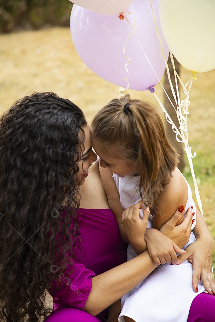 Mãe e filha juntinhas comemorando aniversário com balões