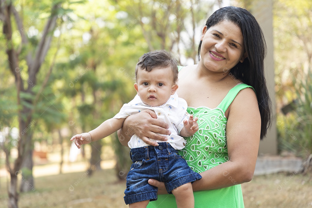 Mãe segurando su acriança fofa no colo e sorrindo