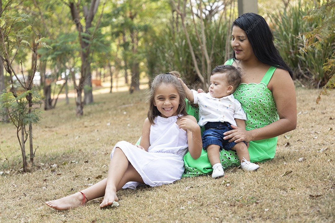 Uma mãe com seus filhos em um parque felizes