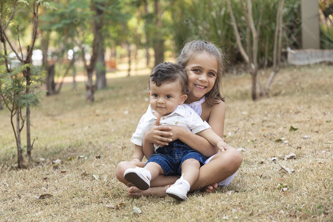 Linda menina segurando seu irmão bebê fofo