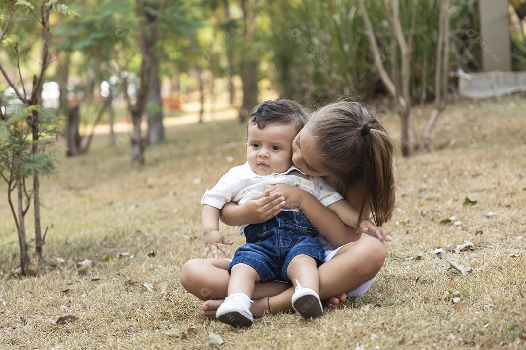 Linda menina segurando seu irmão bebê