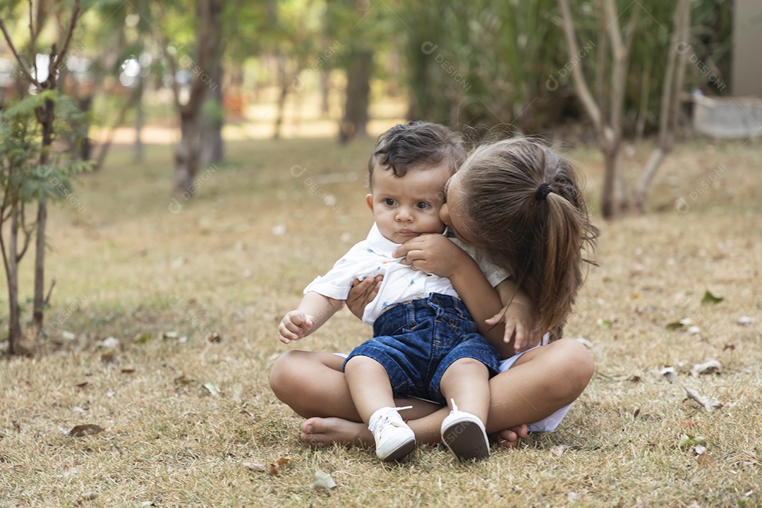 Menina fofa com seu irmãozinho no colo
