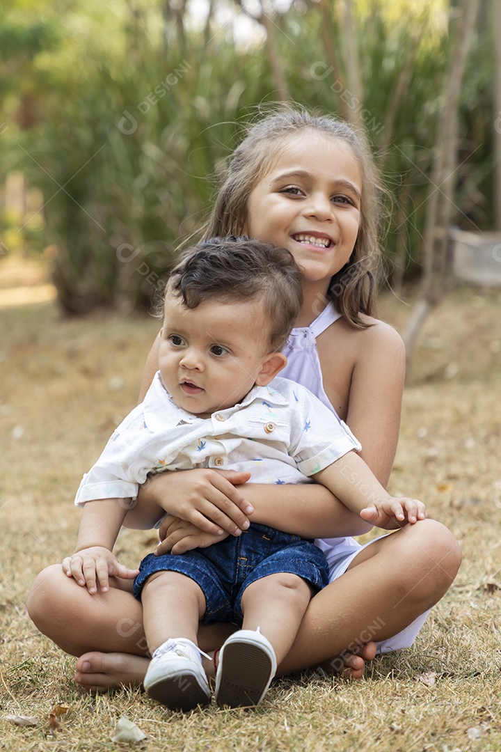 Uma menina segurando seu irmão