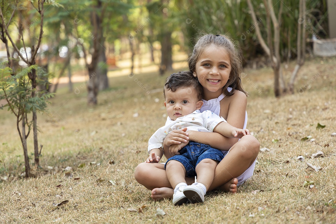 Uma menina segurando seu irmão