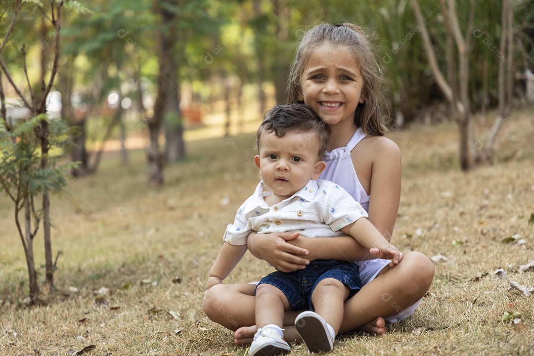 Lindo garotinho no colo da sua irmãzinha