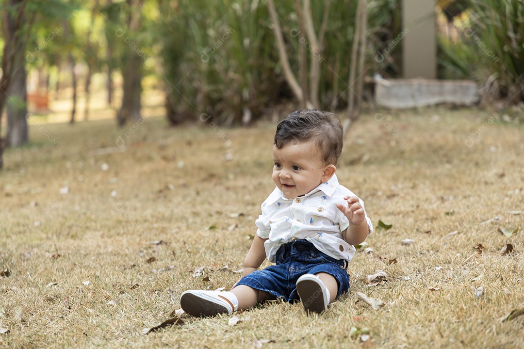 Lindo bebê sentado no gramado