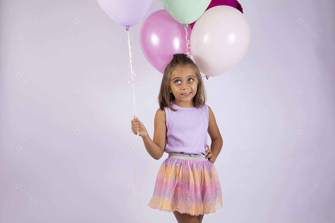 Linda menina com balões coloridos posando para foto