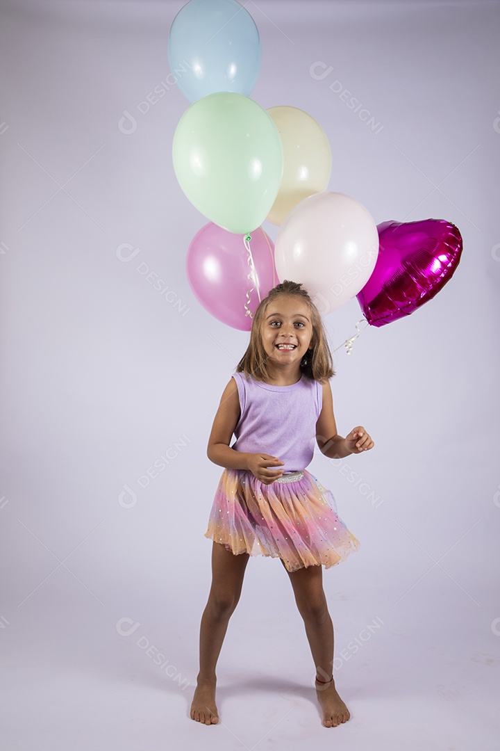 Linda garotinha com balões comemorando aniversário