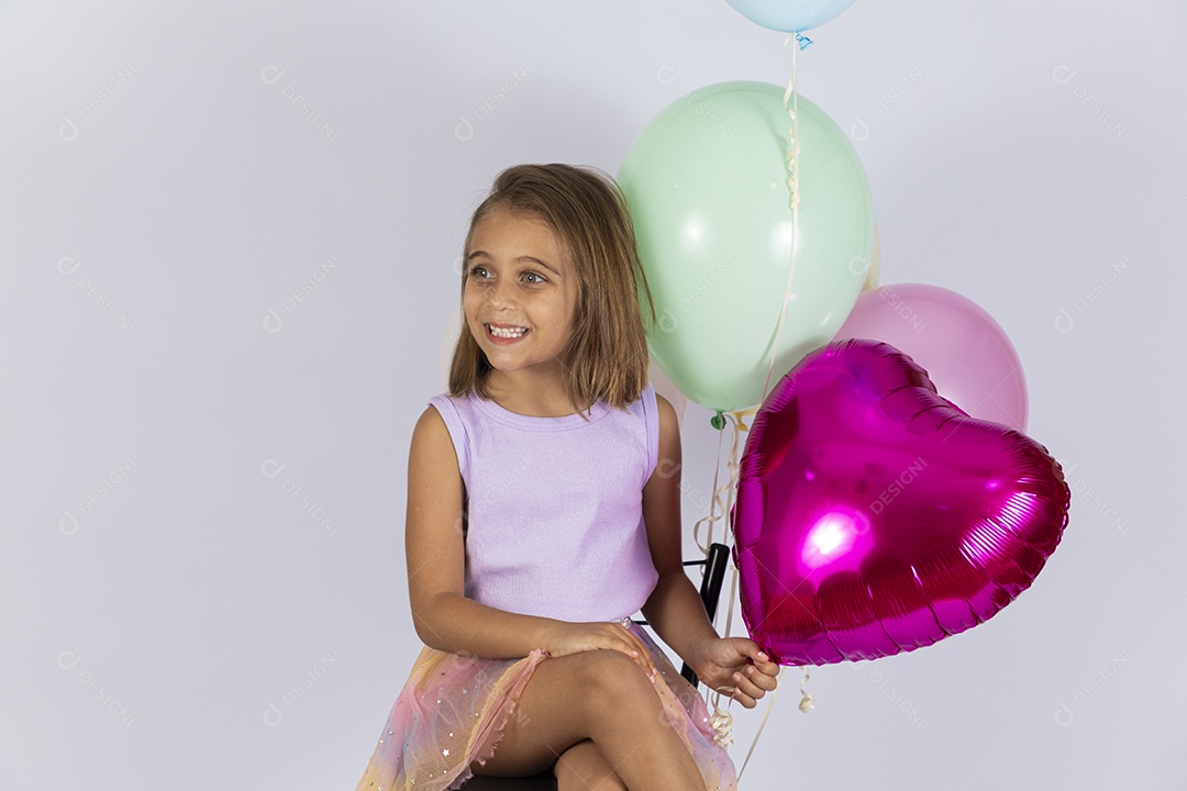 Linda menina com balões coloridos posando para foto