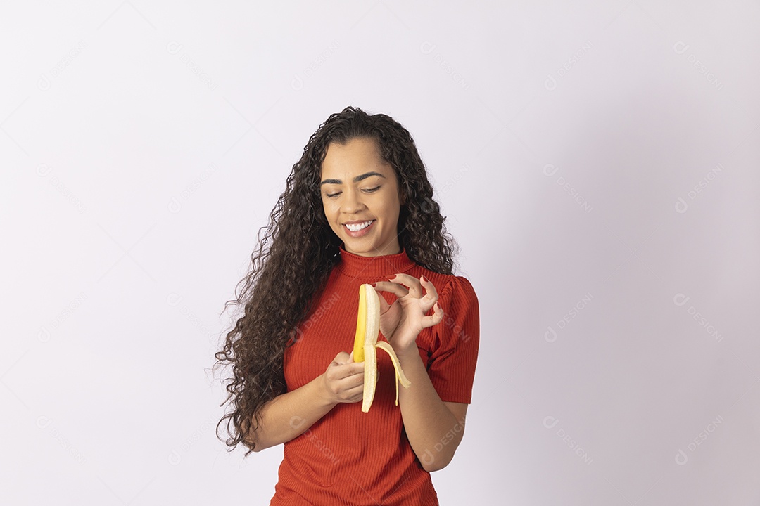 Jovem descascando uma banana para comer