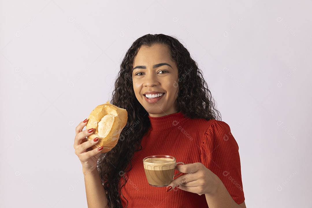 Mulher comendo pão e tomando cappuccino