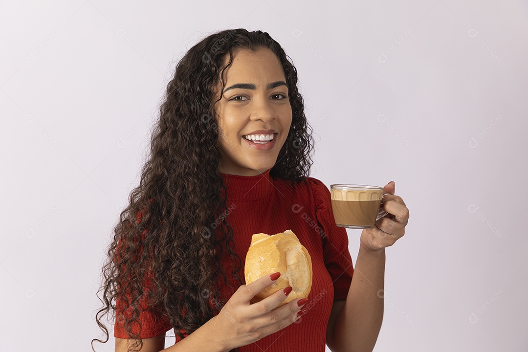Jovem se deliciando com pão e capuucino