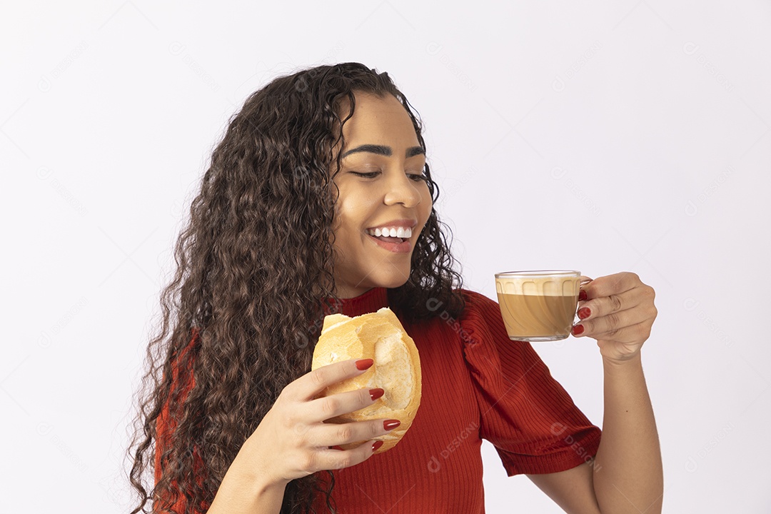Jovem comendo pão e cappuccino